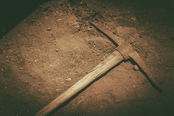 Pickaxe on the Ground Aged Abandoned Pickaxe on the Ground Closeup Photo. Sepia Color Grading. pick axe stock pictures, royalty-free photos & images