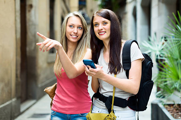 istock Two girls using  smartphone  for find a way 500291225