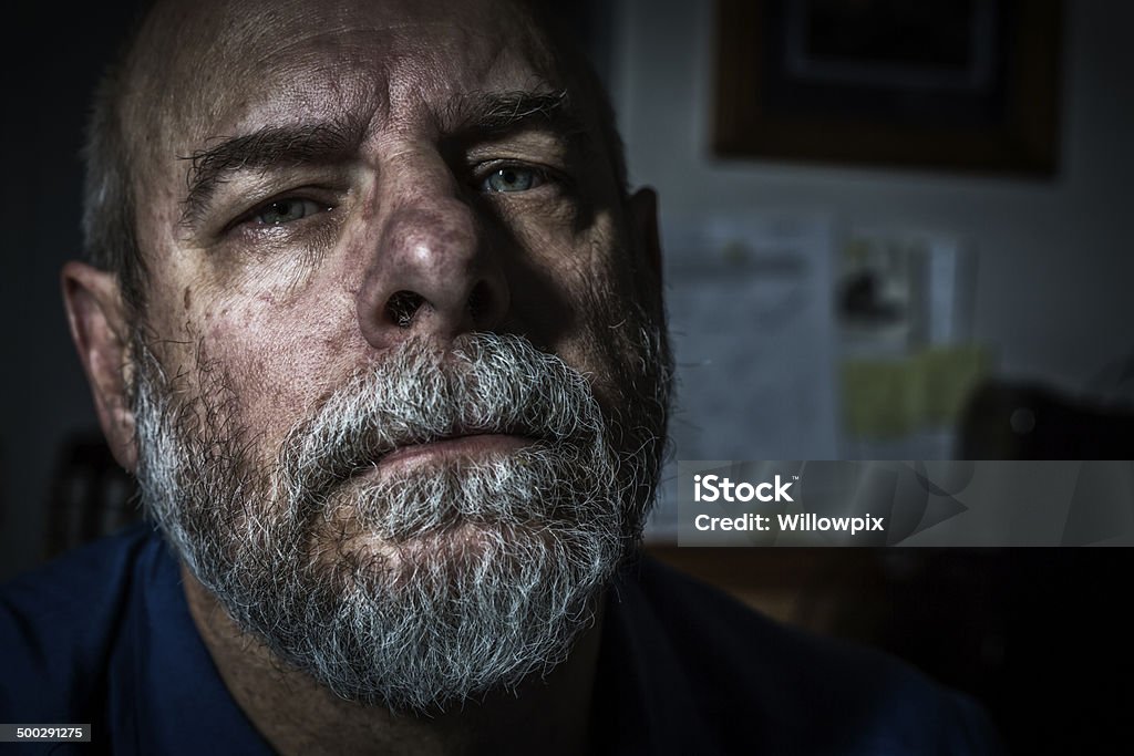 Ominous Man Close-Up Mug Shot Dark and spooky senior man mug shot close-up. Toned image. Anger Stock Photo