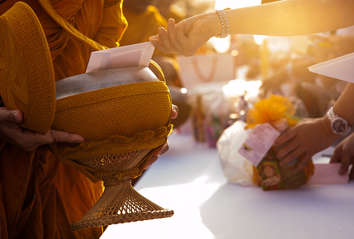 Monk receiving food and items offering from people