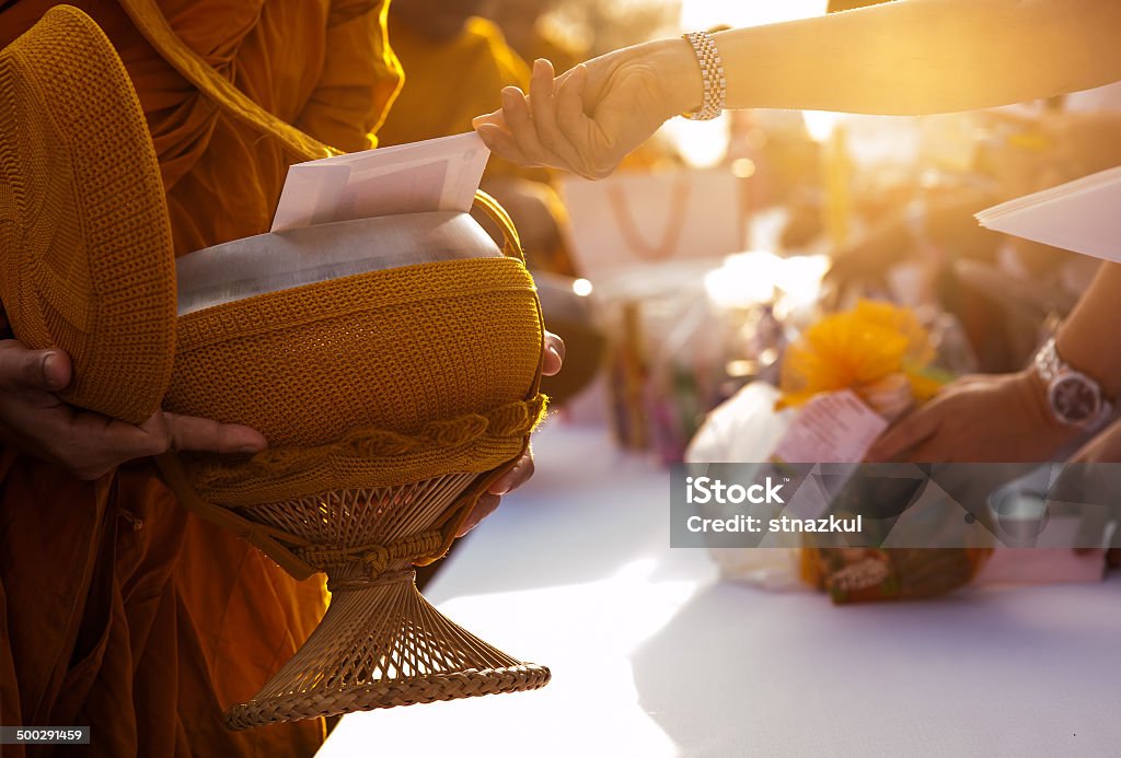 Monk receiving food and items offering from people Monk - Religious Occupation Stock Photo