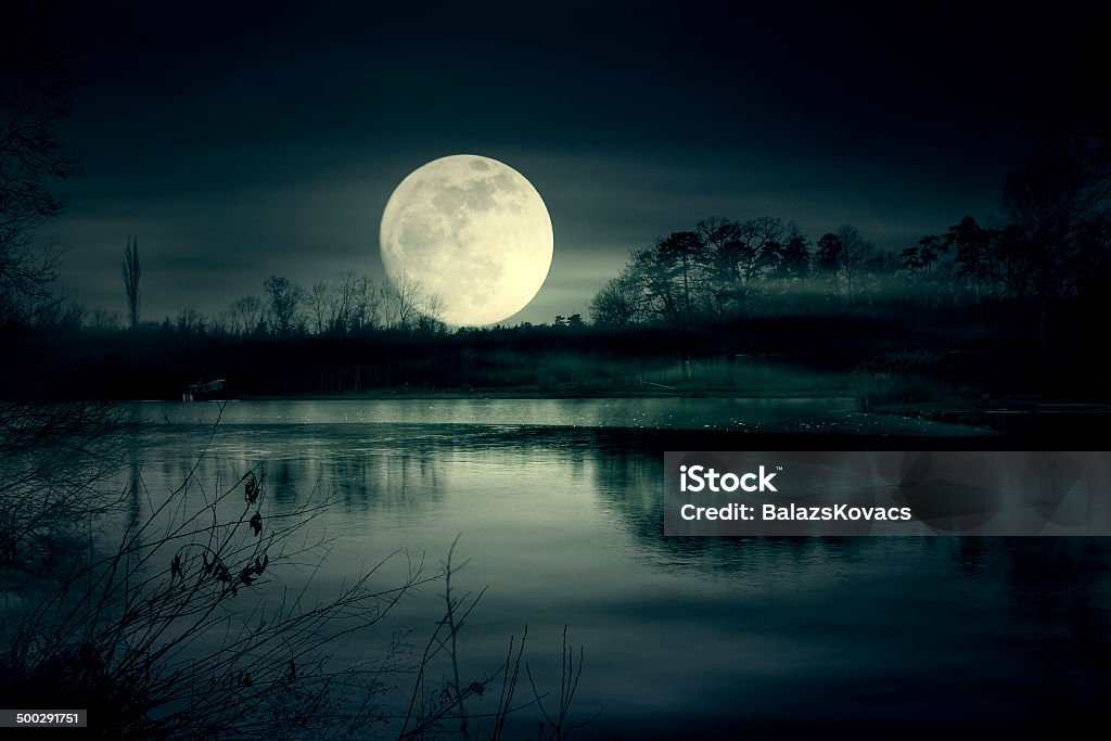 Spooky moonrise over lake Moonrise Moon Stock Photo