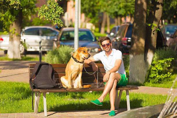 istock man with dog on bench in park. 500292195
