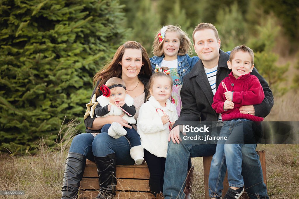 Large Family Christmas Card photo in Christmas Tree Farm . Young family with 4 children poses for holiday photo in Christmas Tree Farm. Happy and smiling. Family Stock Photo