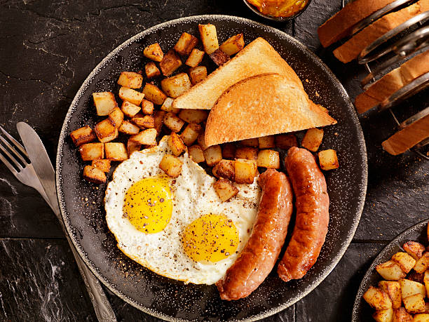 朝食、片面目玉焼き卵とソーセージ - breakfast bacon eggs toast ストックフォトと画像