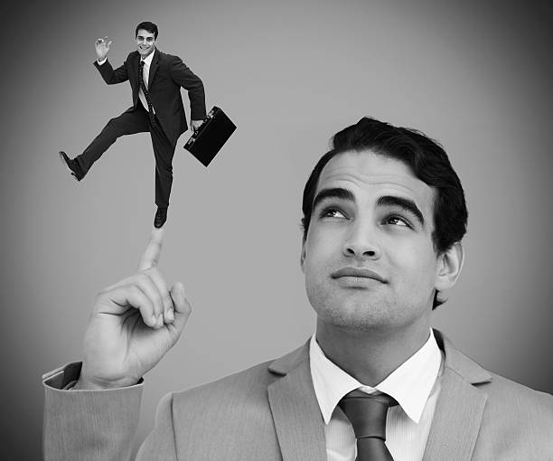 istock Thoughtful businessman showing shrunk colleague dancing on his finger 500295491