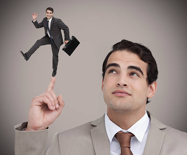 istock Businessman showing shrunk colleague dancing on his finger 500295493