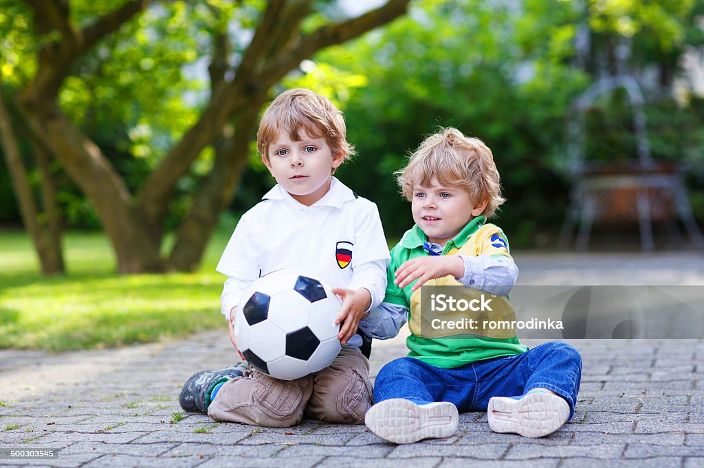 Two little fan boys at public viewing of football game Two little fan boys at public viewing of soccer or football game, outdoors 2-3 Years Stock Photo