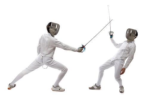 Two fencer in a fencing pose. One is attacking and one is defending. White on black background. Point.