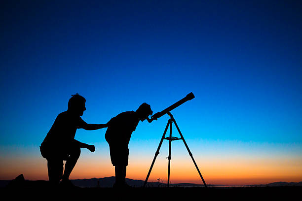 istock Father and son looking thru a telescope 500305805