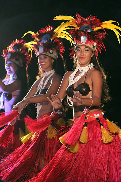 Polynesian Hula Dancers at a Luau - Maui, Hawaii Maui, Hawaii, USA July 19, 2013: Three 	Polynesian Hula dancers performing for an audience at a luau on Wailea Beach. hula dancer stock pictures, royalty-free photos & images