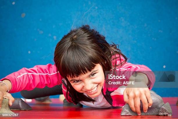 Pretty Girl Climbing A Red Wall In A Playground Stock Photo - Download Image Now - Climbing Wall, Child, 6-7 Years