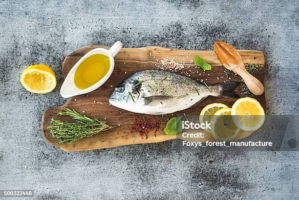 Fresh Uncooked Dorado Or Sea Bream Fish With Lemon Herbs Stock Photo - Download Image Now