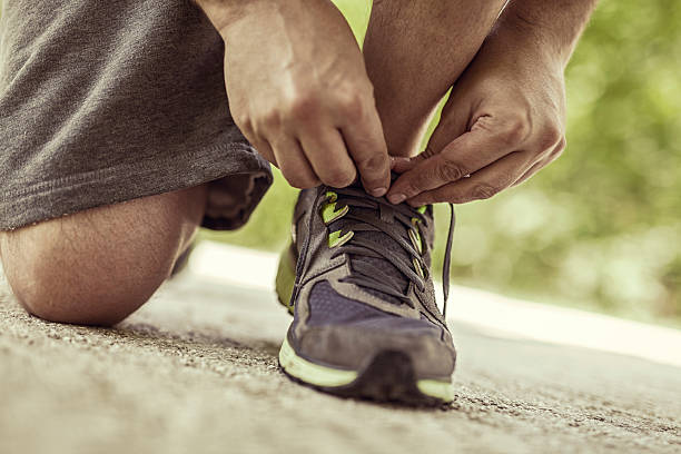 istock tying sports shoe on road 500322723