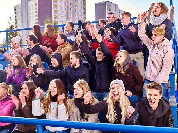 Sport fans clapping and singing on tribunes stock photo