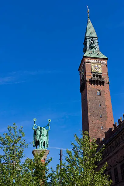 Copenhage town hall tower and statue of the hornblowersm also called the "Lurblaeserne". The horns, "lur" in danish,  are used as a quality symbol  for danish butter.