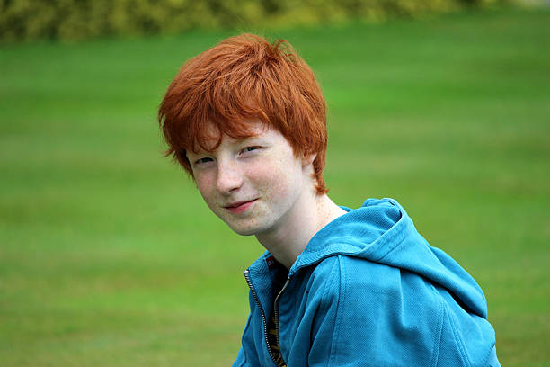 jeune garçon avec coupe de cheveux courte rouge souriant dans le jardin, rire - child blank expression pensive focus on foreground photos et images de collection