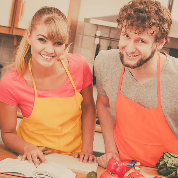 istock Couple cooking in kitchen reading cookbook 500326188
