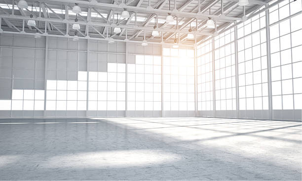 Empty warehouse showroom Vast Empty warehouse for car aor placment of automobile, sun light coming through windows center of the universe stock pictures, royalty-free photos & images