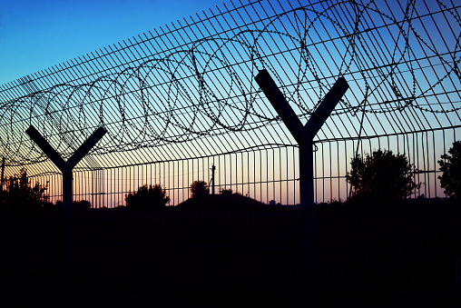 People and cars visible through barbed wire at Katutura Township near Windhoek in Khomas Region, Namibia