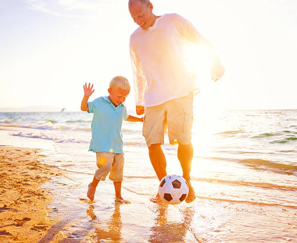 istock Father Son Playing Beach Football Happiness Concept 500329368
