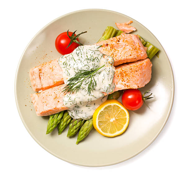 Salmon with steamed asparagus isolated top view