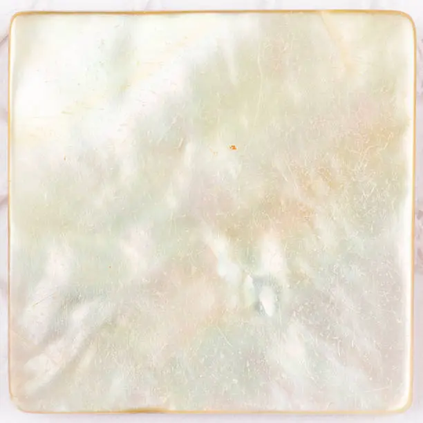 beautiful natural light with iridescent nacre pearl shimmering in the form of a square plate for mosaic