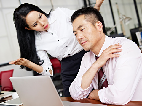 businesswoman puzzled and baffled at her male colleagues behavior.