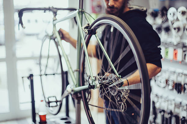 mécanicien de réparer un vélo - candid people casual bicycle photos et images de collection