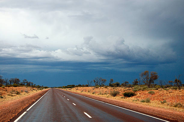 Straight road at australian outback cloudy sky