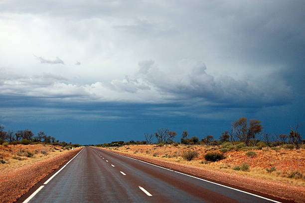 Straight road at australian outback cloudy sky Straight road at australian outback cloudy sky, South Australia, Stuart Highway darwin nt stock pictures, royalty-free photos & images
