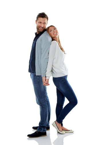 Full length portrait of caucasian man and woman standing back to back over white background.