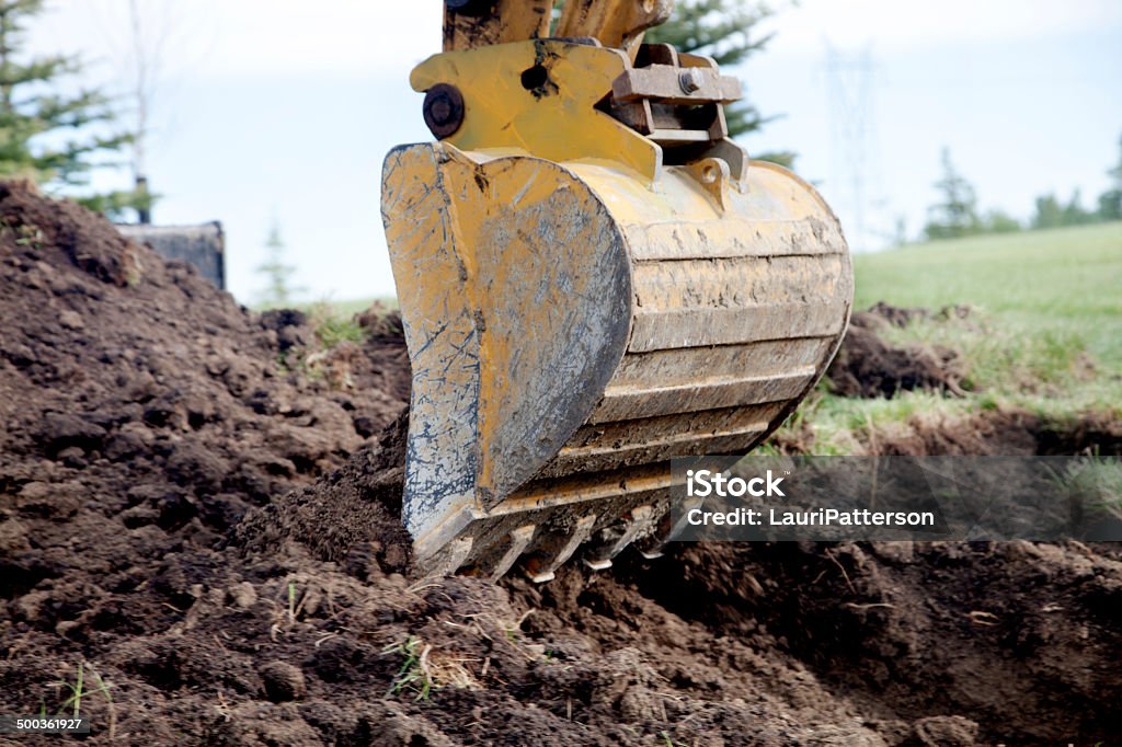 Backhoe A Backhoe Digging a Trench Digging Stock Photo