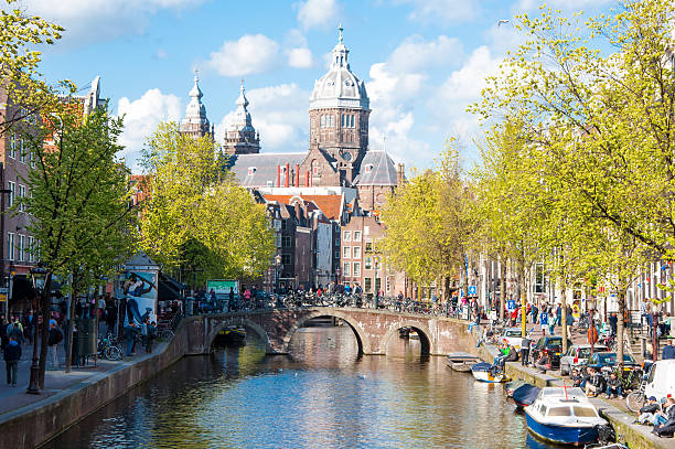 Red light district, crowd of tourists go sightseeing, Amsterdam. Amsterdam, the Netherlands-April 30,2015: Red light district, crowd of tourists go sightseeing, the Church of St. Nicholas is visible in the distance. wellen stock pictures, royalty-free photos & images