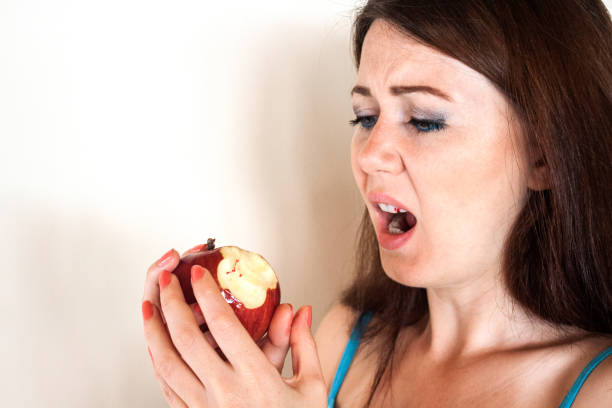 Girl looking to bloodshot apple sadly stock photo