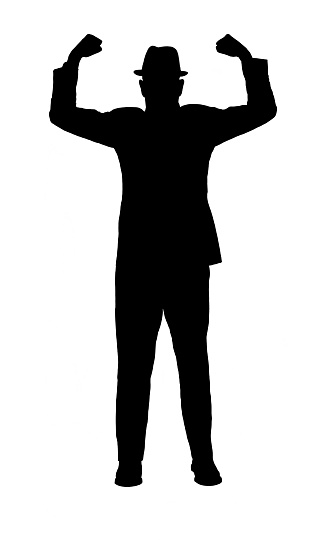 Silhouette of a man in a suit and hat with arms raised to show strength 