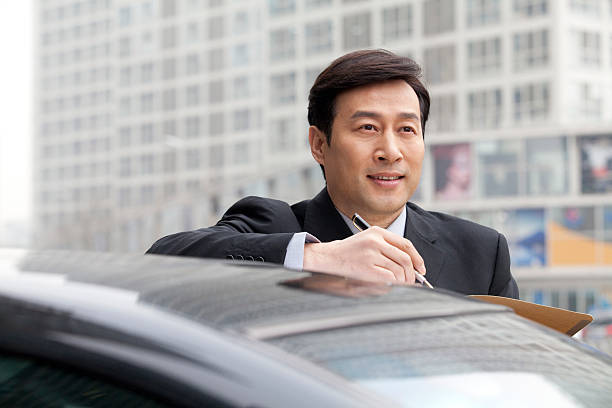 istock Businessman working outdoors on car 500364389