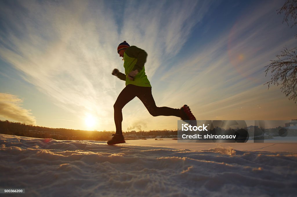 Running in winter Young sportsman running in snow 2015 Stock Photo