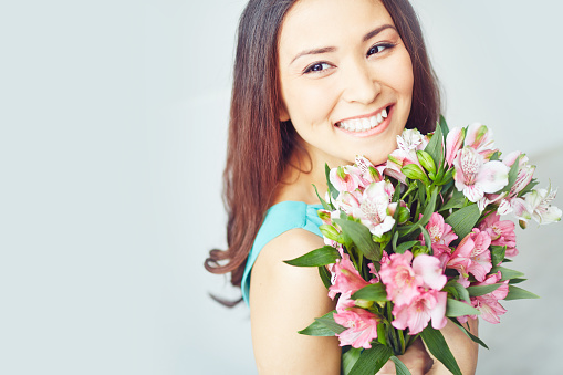 Smiling young woman holding floral bouquet
