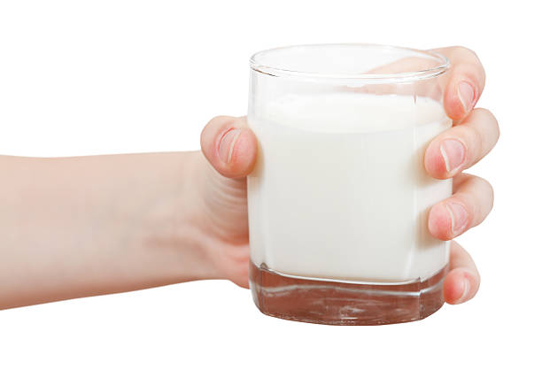 istock hand holds glass of milk isolated on white 500366721