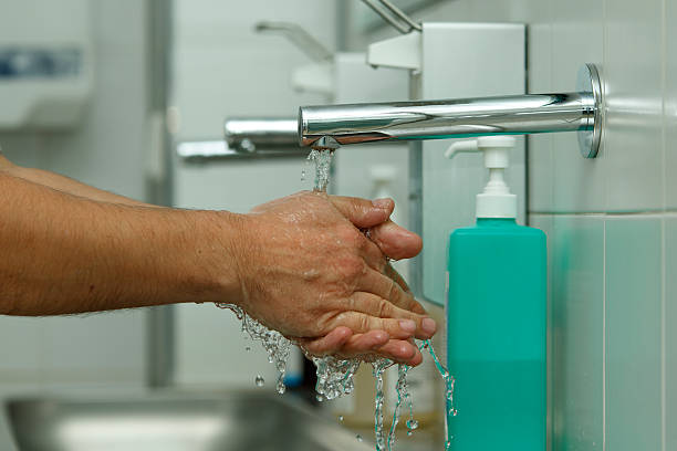 Hand washing hand washing at the hospital with water spray frozen in moment water sanitation worker washing faucet stock pictures, royalty-free photos & images