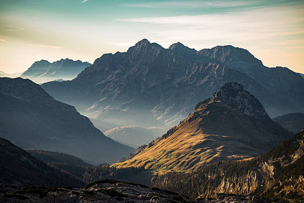 späten herbst sonnenuntergang über alpine wiesen und die berge in österreich - gebirge stock-fotos und bilder