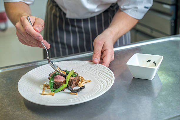 istock Cheerful Chef decorate plate with meat greens. Young chef prepar 500370444