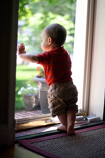 istock Little boy standing at door 500375739