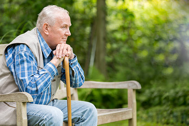 istock Senior man with cane sitting on bench 500376633