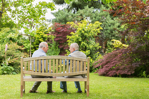 istock Two senior men sitting on bench in the park 500376639