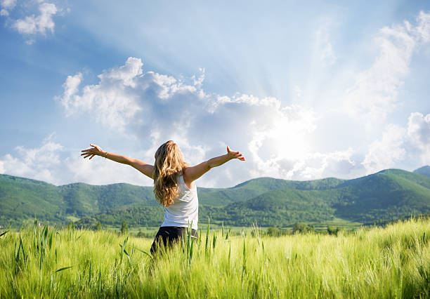 una mujer joven sensación de estar al aire libre en el campo de trigo - arms raised arms outstretched sky human arm fotografías e imágenes de stock