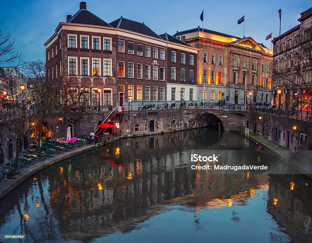Ancient city center of Utrecht, Netherlands Ancient city center of Utrecht, Netherlands features many buildings from the Early Middle Ages. Illuminated Oudegracht area - a canal following the Rhine river - cafes, restaurants and shops Illuminated Stock Photo