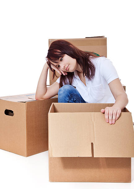 istock Young woman sitting within moving boxes 500388226