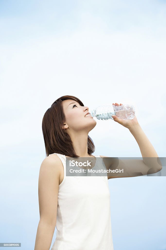 Pretty asian girl drinking water in the blue sky Health and beauty image. Women Stock Photo